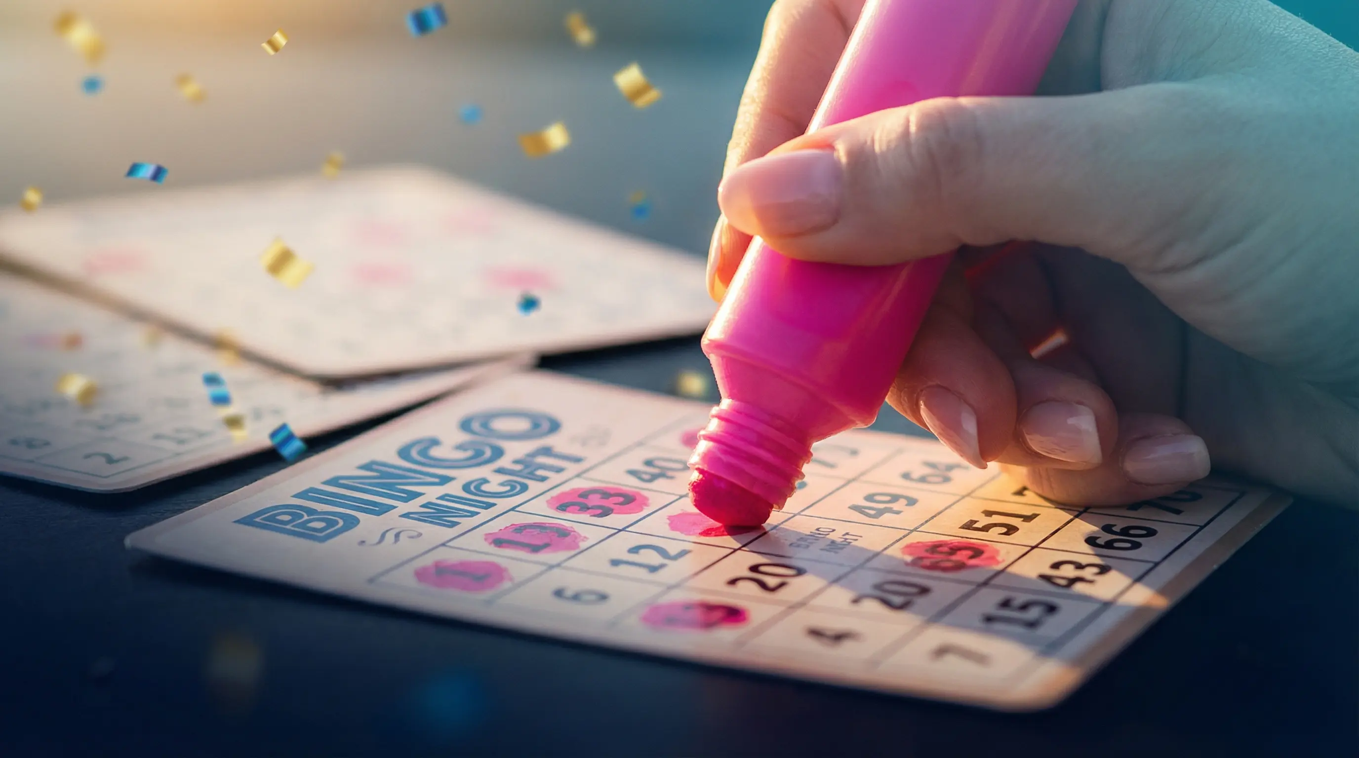 Hand markiert Bingo-Karte mit pinkem Stift in festlicher Atmosphäre